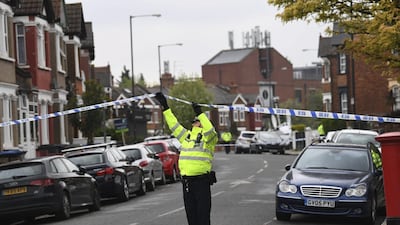 A police officer mans the cordoned off area in London's Harlesden Road on April 28, 2017, after British counter-terror police shot a woman and arrested several people in raids in London and southeastern England. Stefan Rousseau / PA via AP