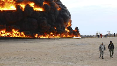 Firefighters try to put out the fire in an oil tank in Es Sider port after clashes between forces allied to competing governments. Photo: Reuters