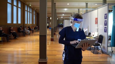 A health worker works at a Covid-19 vaccination center set up at the Royal Melbourne Exhibition Centre in Melbourne, Australia. Bloomberg