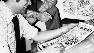 Stan Lee discusses a "Spiderman" comic book cover with artist John Romita at Marvel headquarters in New York., in 1976. AP Photo