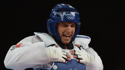 Italy's Carlo Molfetta celebrates after winning against Mali's Modibo Keita at the end of their men's taekwondo semi-final bout in the + 80 kg category as part of the London 2012 Olympic games, on August 11, 2012 at the ExCel centre in London. AFP PHOTO / ALBERTO PIZZOLI *** Local Caption *** 227869-01-08.jpg