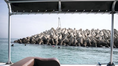 The divers' boat speeds past the sea wall at Dibba as they head out to sea