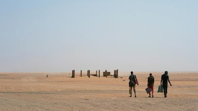 Three men head north towards Algeria after crossing the Assamaka border post in northern Niger in June. AP