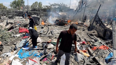 Palestinians inspect the damage from Israeli strikes on a tent camp in Al Mawasi. The strikes were reportedly targeting Hamas military commander Mohammed Deif. Reuters