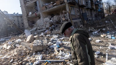 A man walks amid debris in front of a Kyiv residential apartment complex that was heavily damaged by a Russian attack on March 18. Getty