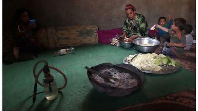 A Palestinian refugee prepares food for her children in their house in Gezirat Al Fadel village, Sharqiya, about 150 kilometres east of Cairo.