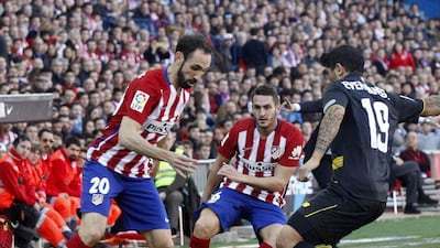 Atletico Madrid defender Juanfran, left, and midfielder Koke fight for the ball with Sevilla midfielder Ever Banega. Fernando Alvarado / EPA