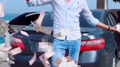 A man has been arrested by Dubai Police after posting footage of himself throwing a pile of money on social media. Courtesy Dubai Police