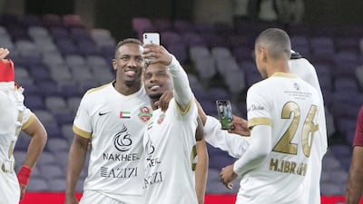 Ahmed Khalil, left, celebrates winning the AGC Cup final with Shabab Al Ahli teammates following a 3-1 extra-time win over Al Wahda at Hazza bin Zayed Stadium in Al Ain on Saturday. All photos by Leslie Pableo for The National