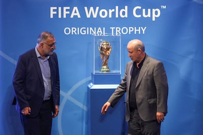 President of Iran Football Federation Mehdi Taj, right, and Mayor of Tehran Alireza Zakani stand next to the Fifa World Cup trophy in Tehran prior to the Qatar 2022 tournament. Reuters