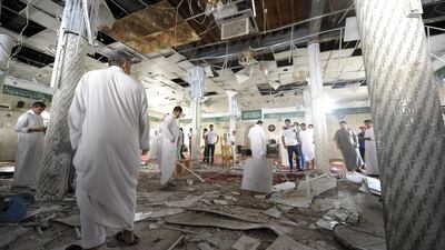 Saudi men gather around debris following a blast inside a mosque, in the mainly Shia Saudi Gulf coastal town of Qatif (AFP PHOTO / STR)