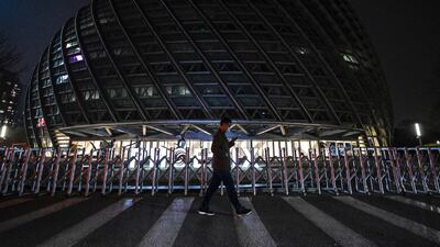A man walks past the Phoenix Center after its lights are turned off for the Earth Hour environmental campaign in Beijing. AFP