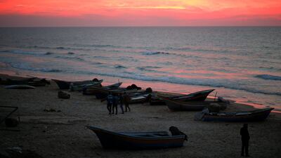 Palestinians walk along a beach in Gaza City. Mohammed Salem / Reuters