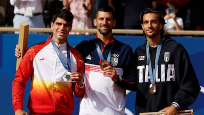 Silver medal winner Carlos Alcaraz, of Spain, gold medal winner Novak Djokovic, of Serbia, and bronze medal winner Lorenzo Musetti of Italy. EPA
