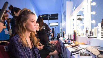 A model has her hair tended to backstage at Kage at Fashion Forward. Courtesy Getty Images