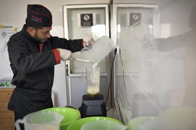 Mohammed Wishah, 37, pours a mixture into a blender in Gelato di Gaza's production room. Rosie Scammell for The National