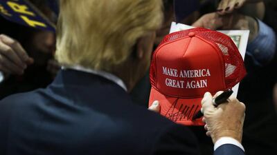 Republican presidential candidate Donald Trump signs one of his campaign hats during an event in Iowa this winter. Joe Raedle / Getty Images