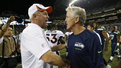 Seattle Seahawks head coach Pete Carroll, right, shakes hands with Denver Broncos head coach John Fox, left, after the Seahawks beat the Broncos 40-10 in a pre-season game at Seattle. The two teams square off in Super Bowl XLVIII on February 2, 2014, at East Rutherford, NJ. John Froschauer / AP Photo