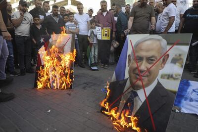 Palestinian demonstrators burn pictures of US President Donald Trump and Israeli Prime Minister Benjamin Netanyahu during a demonstration against the plans to annex parts of the occupied West Bank AFP