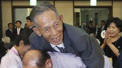 North Korean family member Sin Kyong Muk, 82, is carried by his South Korean niece’s husband Jeong Wu-il, 55, on his back during the Separated Family Reunion Meeting at Diamond Mountain resort in North Korea. Yonhap via AP
