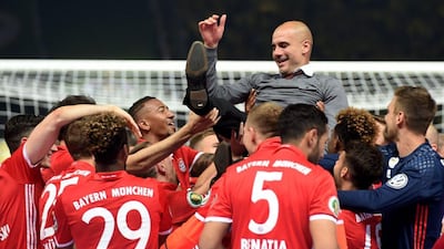 Bayern Munich's players throw their coach Pep Guardiola in the air after defeating Borussia Dortmund in the penalty shootout of the German Cup. Gaurdiola will take over at Manchester City this summer. AFP / CHRISTOF STACHE