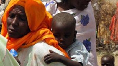 A Sudanese woman carries her son on her back at al-Salam camp for internally displaced persons near Nyala in South Darfur.