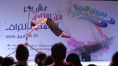 Visitors watch a performer on the open air stage at the Al Gharbia Watersports Festival.