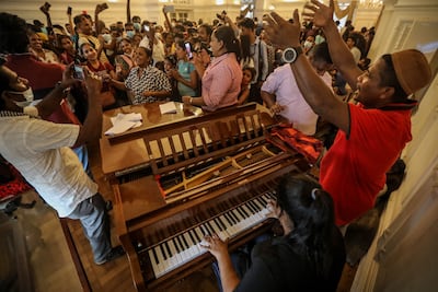 People sing songs inside the prime minister's official residence in Colombo, Sri Lanka, on July 11, two days after official residences were stormed. EPA