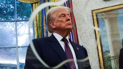 US President Donald Trump looks on during Apple's announcement of a $100 billion investment in US manufacturing, in the Oval Office at the White House in Washington. Reuters