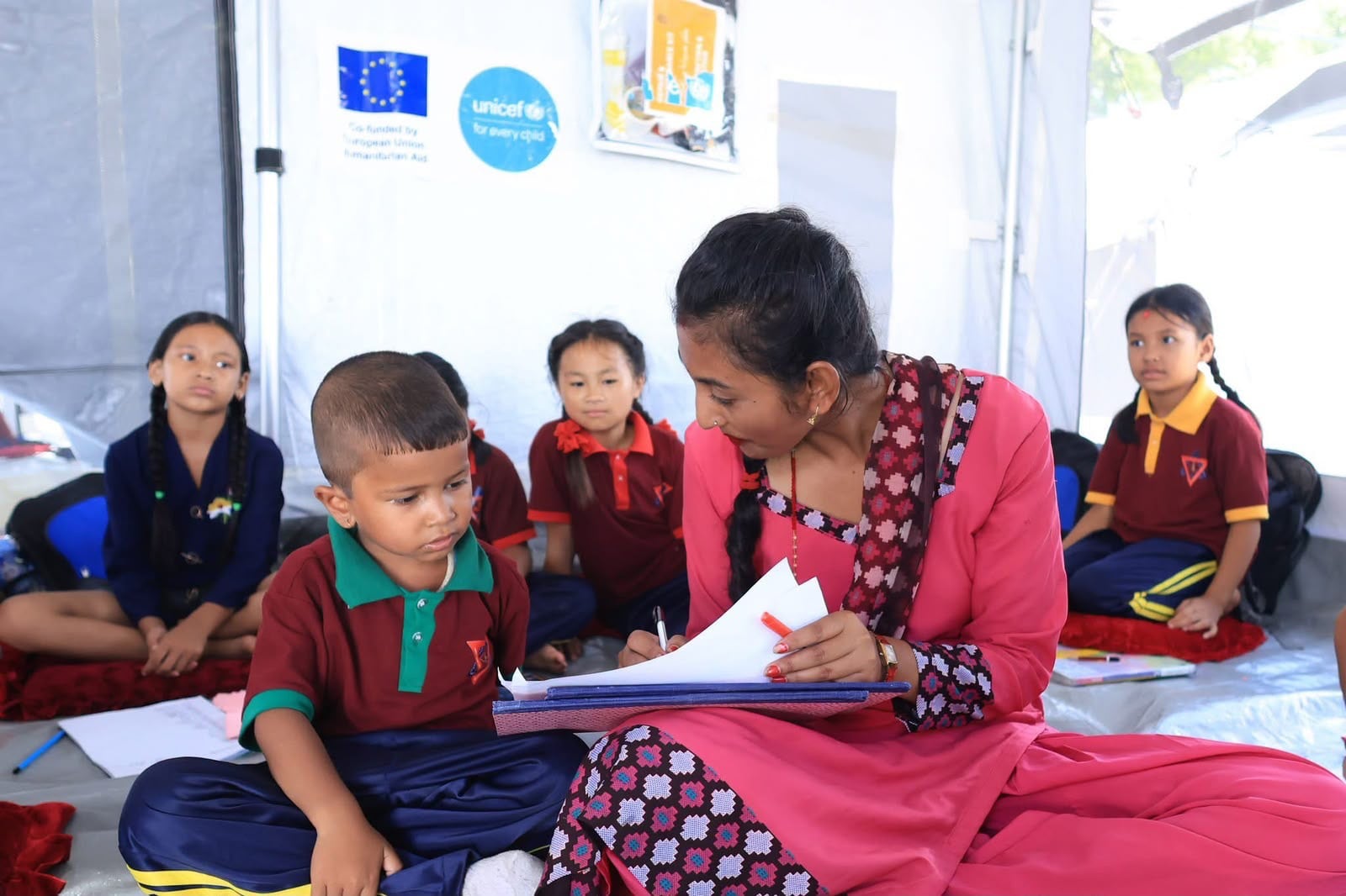 Children sit on the floor as classes are conducted at the makeshift Tribhuvan Trishuli secondary school in Nuwakot, Nepal. Photo: Rajendra Dawadi