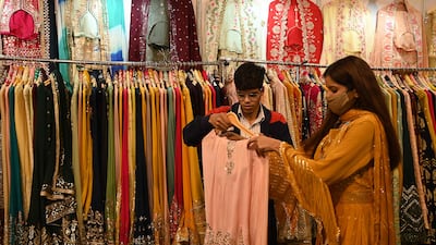 A vendor shows a dress to a customer in New Delhi. India's economy is bouncing back amid improved spending after the government eased pandemic-related restrictions. Photo: AFP