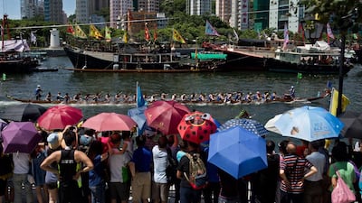 Spectators watch as competitors paddle their boats during the annual Dragon Boat Festival in Hong Kong on Saturday. Dale de la Rey / AFP