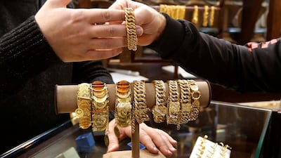 A salesman handles gold bracelet to a customer inside a jewellery shop in Beirut, Lebanon. REUTERS