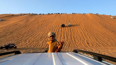 A child waves from the base of the Moreeb dune at the 2020 Liwa Festival. Victor Besa / The National