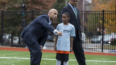 The UAE Ambassador to the United States, Yousef Al Otaiba, talks to a school pupil during the launch ceremony for the US$1.5m UAE-funded football pitch in Washington DC.