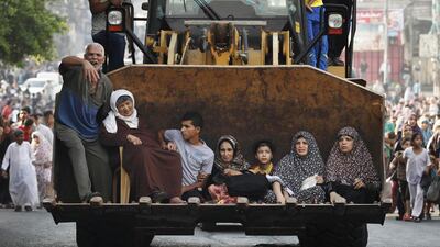 Palestinians sit in the bucket of an excavator as families flee the Shujayeh neighbourhood during heavy Israeli shelling in Gaza City. Finbarr O’Reilly / Reuters
