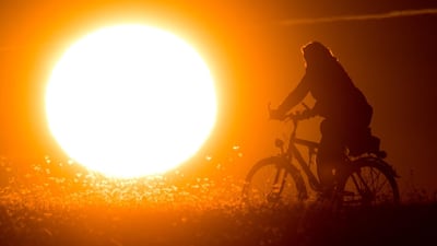 A cyclist silhouetted against the morning sun in Hanover, Germany. AFP
