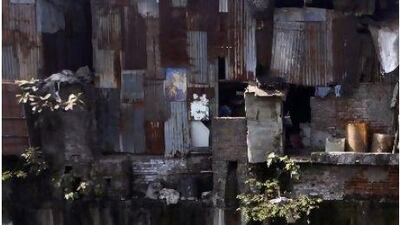 A rag picker sifts through garbage to collect plastic items that can be resold in market, in a dirty rivulet in Dharavi, Mumbai. Dharavi is one of the world's largest slums, with more than 6,000 residents. Rafiq Maqbool / AP Photo