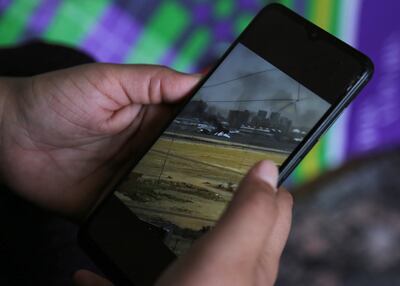 Rawan Al Waleed, a Sudanese woman who fled Khartoum for her aunt's house in Cairo, looks at pictures of fighting in Sudan. Reuters