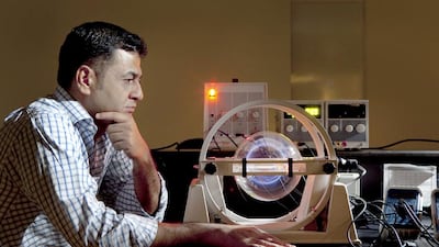 Dr Ali Al Naser, a physics teacher at American University of Sharjah, studies the effects of firing lasers into hydrocarbons. Photographed in his lab with a charge to mass ratio apparatus that is used to measure the charge of electrons. Antonie Robertson / The National
