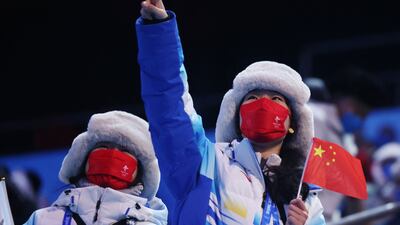 A woman wearing a face mask holds a Chinese national flag before the Beijing 2022 Winter Olympics. Reuters