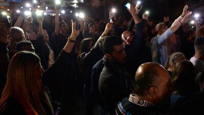 Protesters lighting up their phones and shout slogans as they block the highway leading to the Presidential palace during a protest to demand the formation of a new government in Baabda. EPA