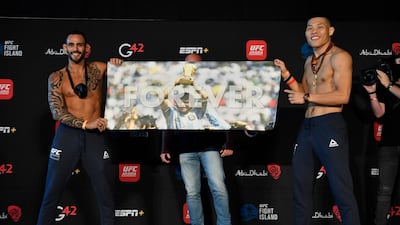 Santiago Ponzinibbio of Argentina and Li Jingliang of China hold up a sign honoring Diego Maradona during the UFC weigh-in at Etihad Arena on UFC Fight Island in Abu Dhabi. Jeff Bottari / Zuffa LLC / Getty Images / UFC