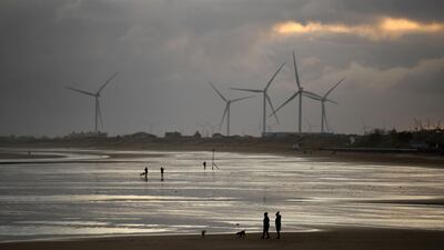 People exercise with their dogs on the beach in Bridlington, north east England. AFP