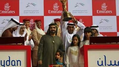 Trainer Mahmoud Al Zarooni raises the trophy won by Monterosso in the Dubai World Cup as, on his right, Sheikh Mohammed bin Rashid, Vice President of the UAE and Ruler of Dubai, looks on.