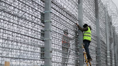Workers construct the concrete wall. Reuters