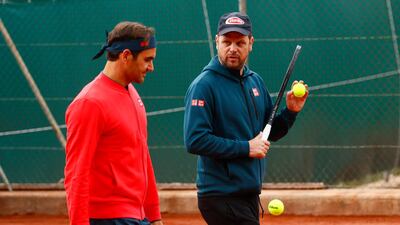 Roger Federer and coach Severin Luethi during training. Reuters