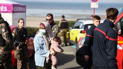A woman and baby alongside rescue units after an attempt to cross the English Channel turned tragic. AFP