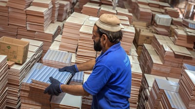 An employee arranges tiles before packing into the boxes at the Shabbir Tiles, which had suffered four years of losses while fighting to compete with cheap imports from neighbouring China, is on course to post an annual profit next financial year after Pakistan placed an anti-dumping duty on Chinese tiles in October. Photographer: Asim Hafeez/Bloomberg
