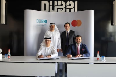 Hadi Badri, left, chief executive of the Dubai Economic Development Corporation in the emirate's Department of Economy and Tourism, and JK Khalil, general manager for Mena East cluster at Mastercard, sign the agreement. Photo: Dubai Media Office